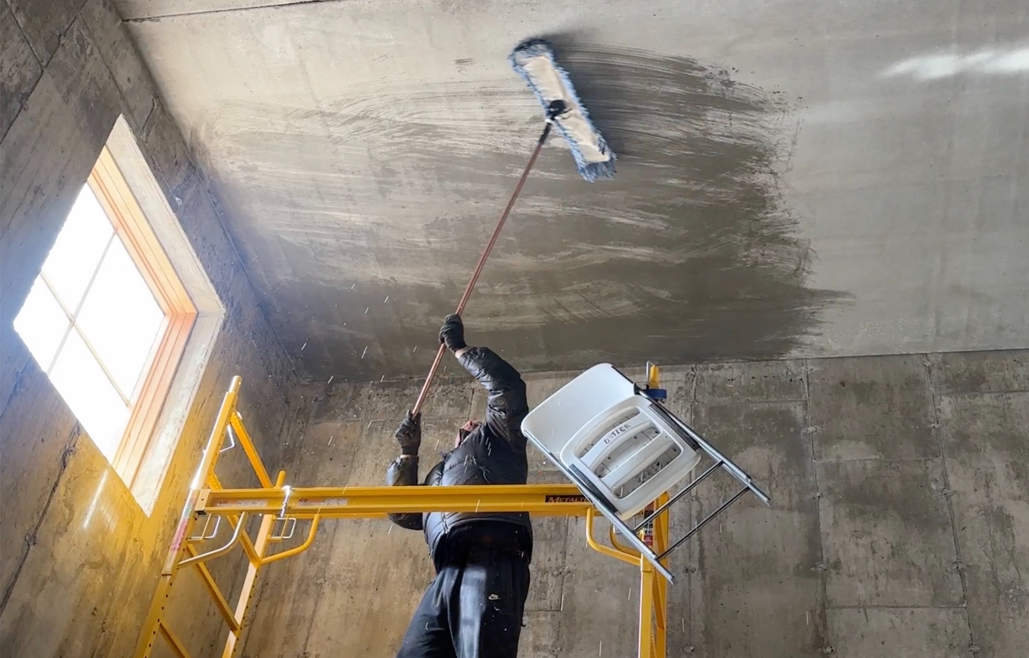 mopping the concrete to prepare for primer